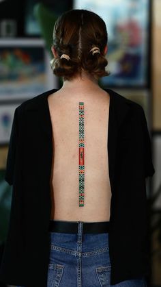 the back of a woman's body with tattoos on her upper and lower back