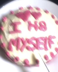 a cake with pink frosting and the words happy birthday written on it is sitting on a white plate