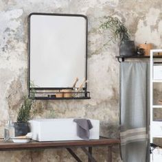 a table with a mirror and some plants on it