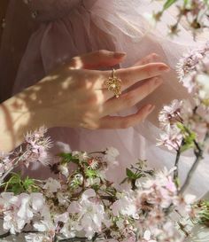 a close up of a person wearing a ring near flowers