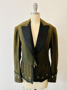 "One-of-a-Kind Vintage Austrian Loden Wool Jacket-Black satin Tuxedo Lapels with Open Front-2 Mini Trim Epaulets-Front flaps with 3 Triangle Crest buttons-Hidden Welt pockets x 2 underneath Truly Bespoke (no label) Vintage Austrian Jacket Traditional Tyrol Blazer Oktoberfest Costume Jacket German Bavarian Tailcoat Shoulder:  16\" Bust:  33\" Waist:  32\" Sleeve:  22\" Length:  23\" Condition:  Very Good, inside acetate lining intact, some fading of wool on top of shoulders and underneath arms consistent with vintage age and provenance" Vintage Tailored Costume Outerwear, Vintage Tailored Outerwear For Costume, Tailored Vintage Outerwear For Costumes, Vintage Tweed Jacket With Buttons, Military Style Fitted Single Breasted Blazer, Fitted Military Style Single Breasted Blazer, Vintage Formal Blazer With Button Cuffs, Austrian Jacket, Jacket Around Waist