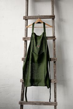 Traditional apron is made from 100% soft and washed linen.  Details: - Colour: Forest green - Composition: 100% Oeko-Tex certified linen - One large pocket - Adjustable with button - Size: One size  - Medium weight linen - Linen care: machine wash gentle; tumble dry low, ironing optional - The price is for one apron, other pictured items are not included Traditional Aprons, Green Apron, Cooking Apron, Womens Aprons, Kitchen Aprons, Linen Bag, Linen Apron, Forest Green, Dining Linens