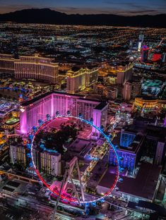 an aerial view of the las vegas strip at night with a ferris wheel in the foreground