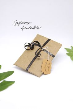 a gift wrapped in brown paper with a black ribbon and tag attached to the side