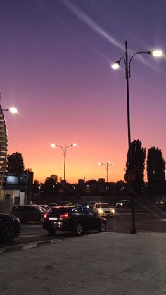 cars are parked on the street at sunset