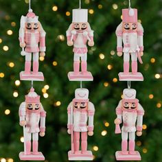 pink and white nutcracker ornaments hanging from a christmas tree