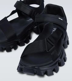 These tank sandals from Prada are made in Italy with woven fabric straps, featuring VELCRO® fastenings, chunky rubber soles, and a rubberized logo at the heel counter..Closure: VELCRO®-fastening ankle strap.Lining: fabric.Made in Italy.Sole: fabric insole, rubber sole.Toe shape: round open toe.Upper: fabric.True to size.Half sizes please take the next size up.UK sizes.6,0cm-2.5' heel (size EU 42) Summer Sport Sandals With Logo Strap And Open Toe, Nylon Sandals With Rubber Sole And Round Toe, Open Toe Nylon Sport Sandals With Removable Insole, Summer Nylon Sport Sandals With Rubber Sole, Sporty Open Toe Nylon Sandals, Black Sport Sandals With Logo Strap For Summer, Prada Double Wheel Sneakers, Prada Cloudbust Thunder Sneakers, Prada Platform Sandals