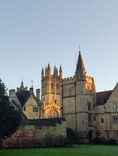 an old building with towers and windows in the middle of it's grass area