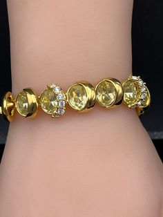 Absolutely gorgeous color and clarity.  The larger stones are pale yellow encased in goldtone design. Richness and delicate.  Very lightweight and comfortable to wear, yet it is a substantial statement of elegance. Dimensions are approximate: Length:  7" Width:  1/2" Weight:  1.31 oz. Gold Oval Tennis Bracelet For Wedding, Gold Oval Bracelet With Cubic Zirconia, Gold Oval Jewelry With Sparkling Stones, Gold Bracelets With Jewels And Cubic Zirconia, Gold Bracelet With Cubic Zirconia Jewels, Oval Gold Jewelry With Sparkling Stones, Gold Crystal Gemstone Bracelet, Gold Gemstone Crystal Bracelet, Gold Crystal Bracelet With Diamond Accents