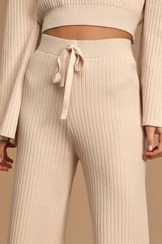 Get cozy on the couch in the Lulus Snuggly Style Cream Ribbed Knit Wide-Leg Pants! These cold-weather essential pants are shaped from ribbed knit and feature a high-waisted fit with decorative drawstring detail, and relaxed-fit, wide pant legs that end in ankle-grazing cropped hems. Pair with the matching sweater for a complete look! Fit: This garment fits true to size. Length: Mid-calf length. Size small measures 35.5" from waist to hem. Waist: Fitted - elastic waist allows stretch. Hip: Fitted Solid Ribbed Winter Pants, Solid Ribbed Lounge Pants, Solid Color Ribbed Pants For Lounging, Solid Ribbed Lounging Pants, Beige Ribbed Pants For Loungewear, Ribbed Beige Pants For Loungewear, Comfortable Ribbed Winter Bottoms, Cozy Ribbed Bottoms For Spring, Cozy Ribbed Bottoms For Winter