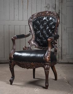 an ornate chair with black leather upholstered on the back