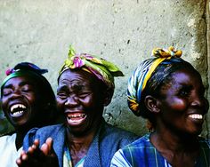 two women laughing while standing next to each other