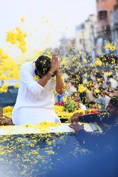 a man is sitting in the back of a car surrounded by yellow confetti