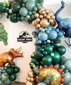 there are many balloons in the shape of animals and dinosaurs on this wall, including one dinosaur