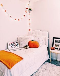 a bedroom with a bed, laptop and pictures on the wall next to each other