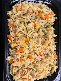 a plastic container filled with rice and veggies on top of a black table