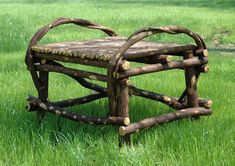 a wooden bench made out of logs in the grass