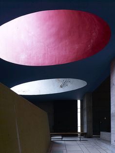 the interior of a building with red and white circles hanging from it's ceiling