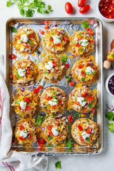 an overhead view of some taco shells on a baking sheet with tomatoes and other ingredients