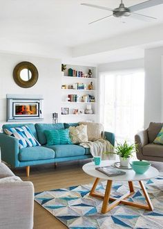 a living room filled with furniture and a ceiling fan in the middle of the room