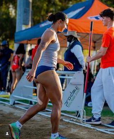 a woman is running in the dirt with other people