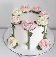 there is a white cake with pink and white flowers on it