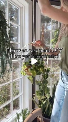 a woman standing in front of a window holding a basket with plants on it and the words here's an easy plant diy i beat you haven