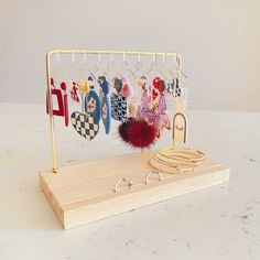 a jewelry rack with several pairs of shoes hanging from it's hooks on a marble countertop