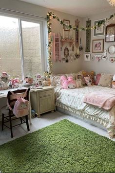 a bedroom decorated in pink and green with lots of stuffed animals on the bed, desks and windows