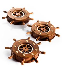 three wooden ships wheels with rivets on them sitting next to each other in front of a white background