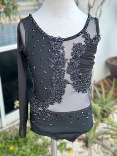 a woman's leotard top with sequins and beads on it