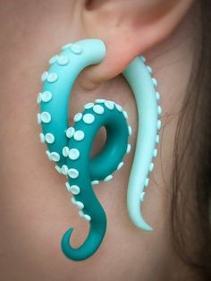 a close up of a pair of ear piercings with an octopus design on them