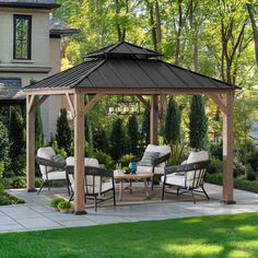 an outdoor gazebo with chairs and table in front of it