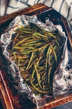 green beans wrapped in tin foil on a tray