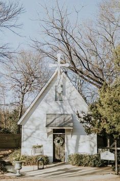 a small white church with a cross on the roof