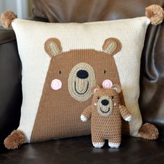 two stuffed bears sitting next to each other on a brown leather chair in front of a pillow