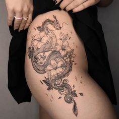 a woman with a dragon tattoo on her thigh