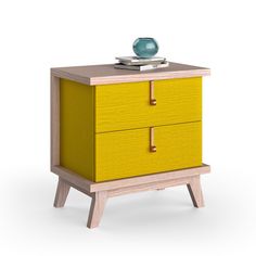 a small yellow cabinet with two drawers and a blue vase on top of the drawer