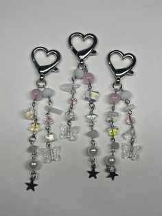 three charms with hearts and stars hanging from them