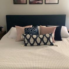 a bed with pillows and pictures on the wall above it