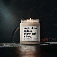 a candle with a quote on it sitting on top of a table next to a cup