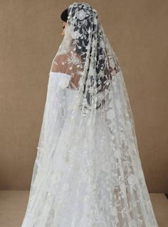 the back of a bride's veil with white flowers on it