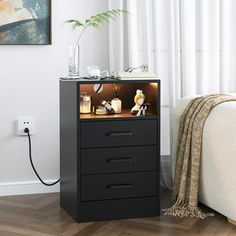 a night stand with two drawers and an electric outlet plugged into the wall next to it