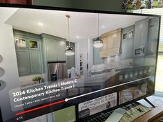 a tv screen showing a kitchen with gray cabinets