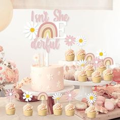 a table topped with cupcakes and cakes covered in frosting