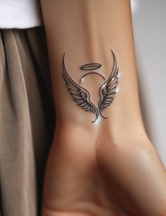 a woman's foot with an angel wing tattoo on the left side of her ankle