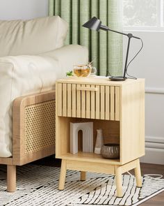 a small wooden table with a lamp on top of it next to a white couch