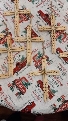 four wooden crosses are sitting on top of a tablecloth with coca colas in the background