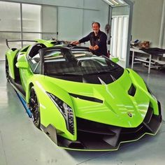 a man standing next to a green sports car