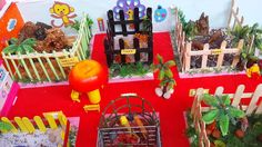 there are many different types of toys on the red tablecloths and in front of them is a fence